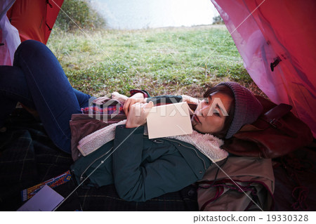 A woman relaxing in a tent 19330328