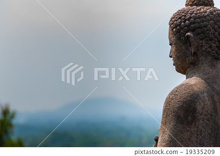 Meditating sitting Buddha in stone above jungle at 19335209