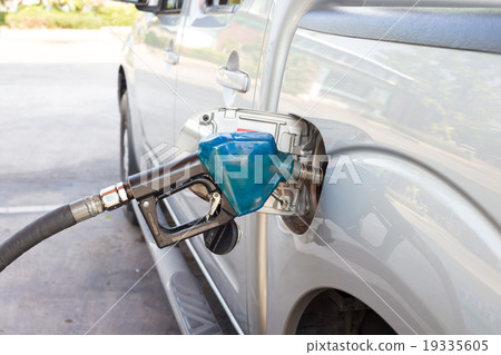 Gas pump nozzle blue in the fuel tank of a bronze 19335605