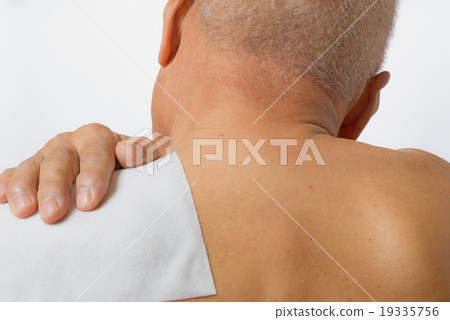 Senior sticking poultice medicine on shoulder 19335756