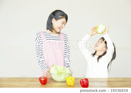 Elementary school girl preparing salad with mother Elementary school girl preparing salad with mother 19336839