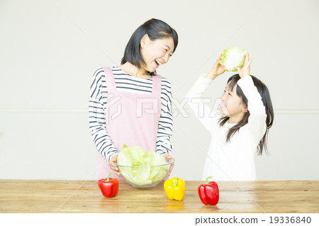 Elementary school girl preparing salad with mother 19336840
