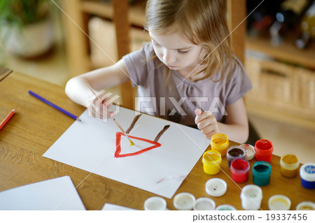 Stock Photo: Cute girl is drawing with paints in preschool