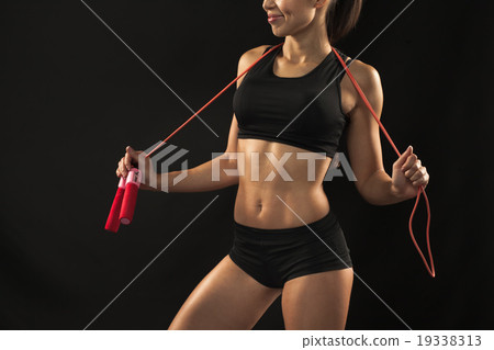 Muscular young woman athlete with a skipping rope Muscular young woman athlete with a skipping rope 19338313