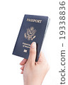 Persons hand holding a passport 19338836