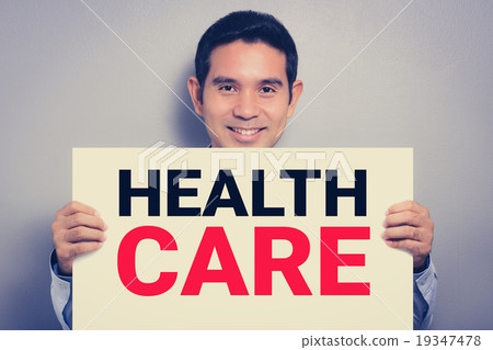 A man with smiling face showing HEALTH CARE sign 19347478