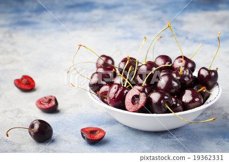 Fresh ripe black cherries on a blue background Fresh ripe black cherries on a blue background 19362331