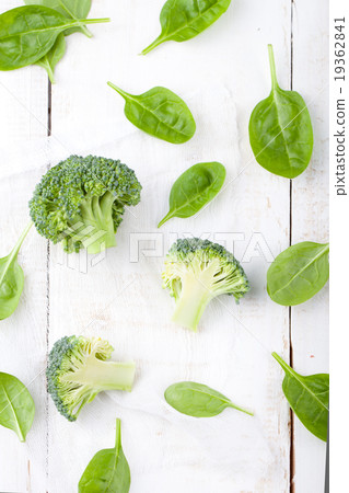 Broccoli and baby spinach on a white background. 19362841