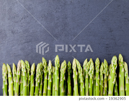 Asparagus sprouts on a black stone background. Asparagus sprouts on a black stone background. 19362905