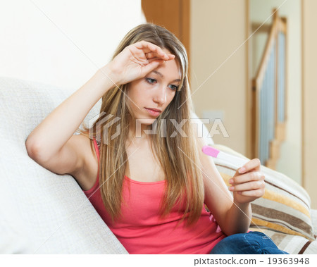 Sad girl with pregnancy test Sad girl with pregnancy test 19363948