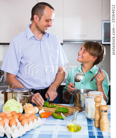 Man and teenager cooking together Man and teenager cooking together 19364012