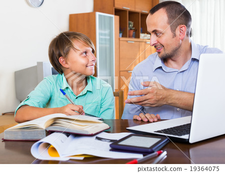 Father helping son to do homework 19364075