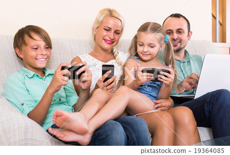 Portrait of family playing with gadgets at home 19364085