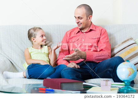 Portrait of father and little girl discussing something indoors 19364172