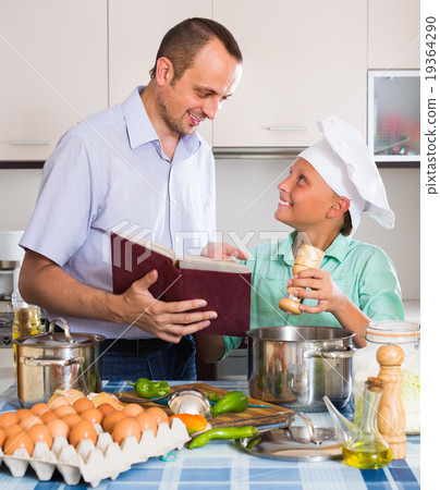 Father and teenage son cooking together. Father and teenage son cooking together. 19364290