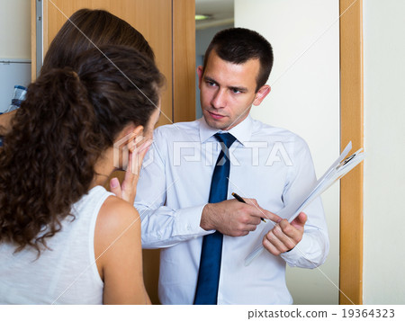 Debts collector and family couple standing in doorway Debts collector and family couple standing in doorway 19364323