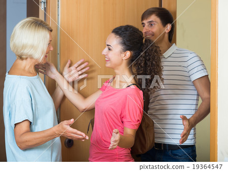 Cheerful senior woman greeting adult children coming with visit Cheerful senior woman greeting adult children coming with visit 19364547