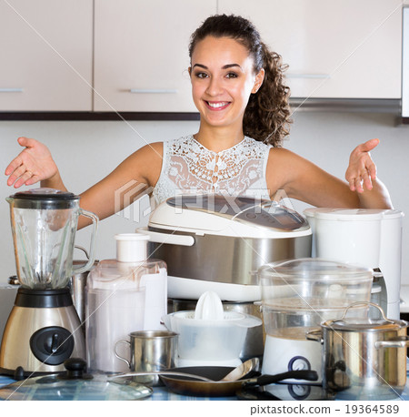 Happy girl posing with appliances at kitchen 19364589