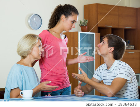 Angry wife and mother-in-law rebuking young man 19364638