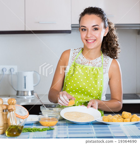 woman rolling filled croquettes 19364690