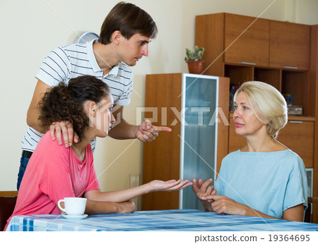 Adult kids demanding something of mature mother indoors 19364695