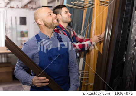 Two workers choosing PVC window profile 19364972