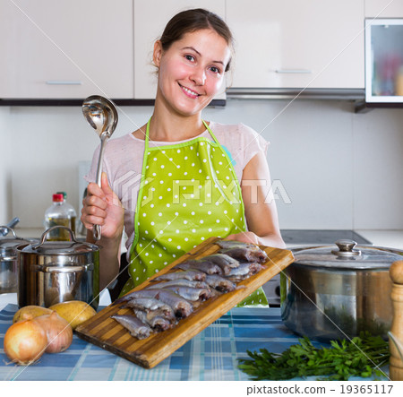 housewife trying new recipe of sprattus in kitchen 19365117