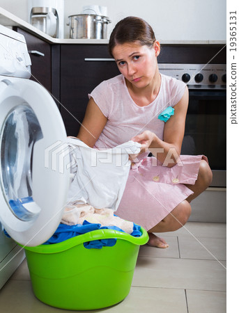Sad woman near washing machine. 19365131
