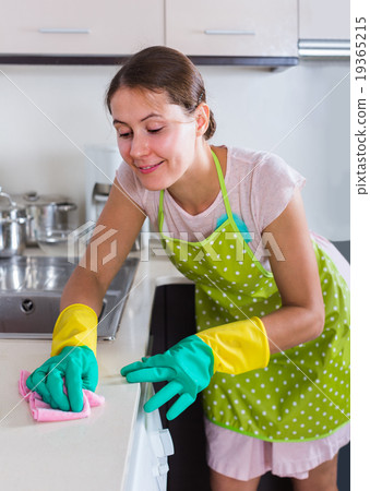 female houseworker with rag and cleanser indoors female houseworker with rag and cleanser indoors 19365215