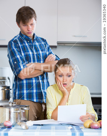 spouses discussing bills and banking statement at home spouses discussing bills and banking statement at home 19365340