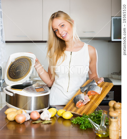 Woman cooking with multicooker 19365510