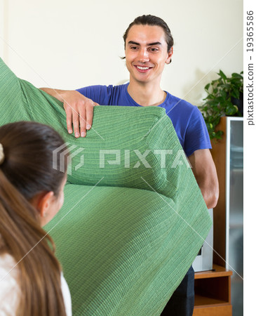 Couple moving furniture in room Couple moving furniture in room 19365586