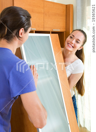Couple moving furniture in room Couple moving furniture in room 19365621