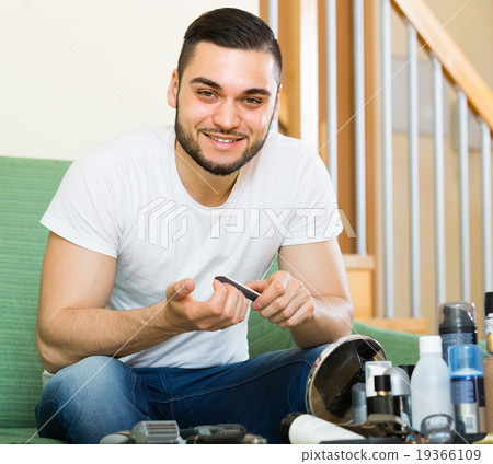 Young guy cutting nails . 19366109
