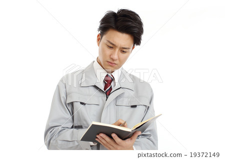 A man wearing a uniform watching a notebook A man wearing a uniform watching a notebook 19372149