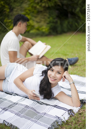 A young couple enjoying some calmness in a park. A young couple enjoying some calmness in a park. 19373844