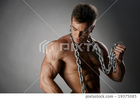 Portrait of tanned bodybuilder posing with chain 19375085