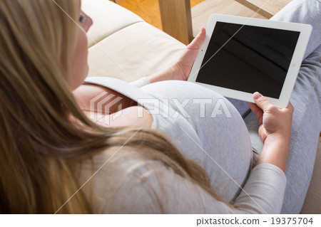 pregnant woman spends time with the tablet pregnant woman spends time with the tablet 19375704