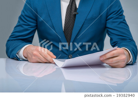 Professional newscaster reading his papers. Professional newscaster reading his papers. 19382940