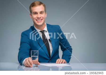 Smiling newsman holding a glass of water. Smiling newsman holding a glass of water. 19382943