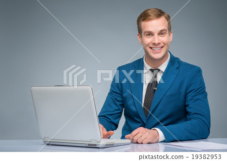 Smiling newsman working with his laptop. Smiling newsman working with his laptop. 19382953