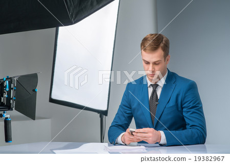 Newsman checking his smartphone 19382967