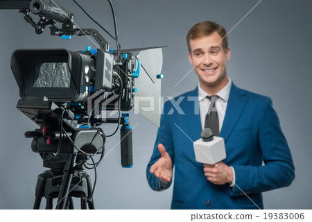 Smiling newsman with a microphone.  19383006