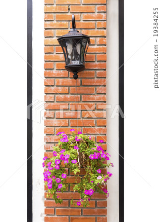 Lamp and flower pot aligned on a wall. Lamp and flower pot aligned on a wall. 19384255