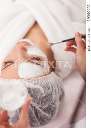 Skillful cosmetician is serving her female 19390092