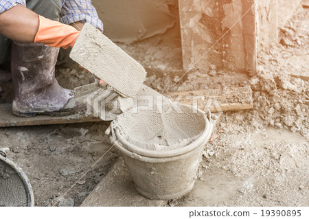 man's hand plastering a wall with trowel. man's hand plastering a wall with trowel. 19390895