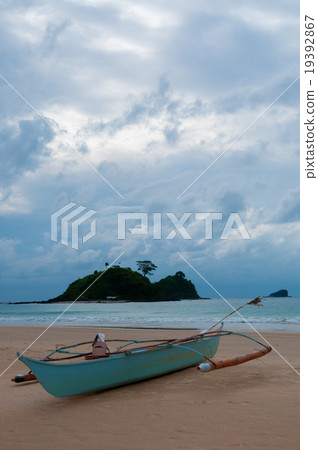 Blue Boat laying on the sand beach in front of Blue Boat laying on the sand beach in front of 19392867