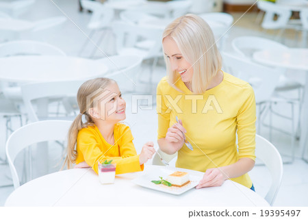 Happy mother and daughter sitting in the cafe  19395497