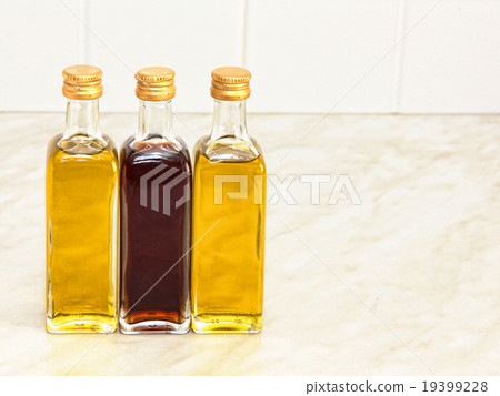 Three vegetable oil bottles on kitchen table. Three vegetable oil bottles on kitchen table. 19399228