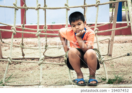 asian boy sitting alone at playground  19407452